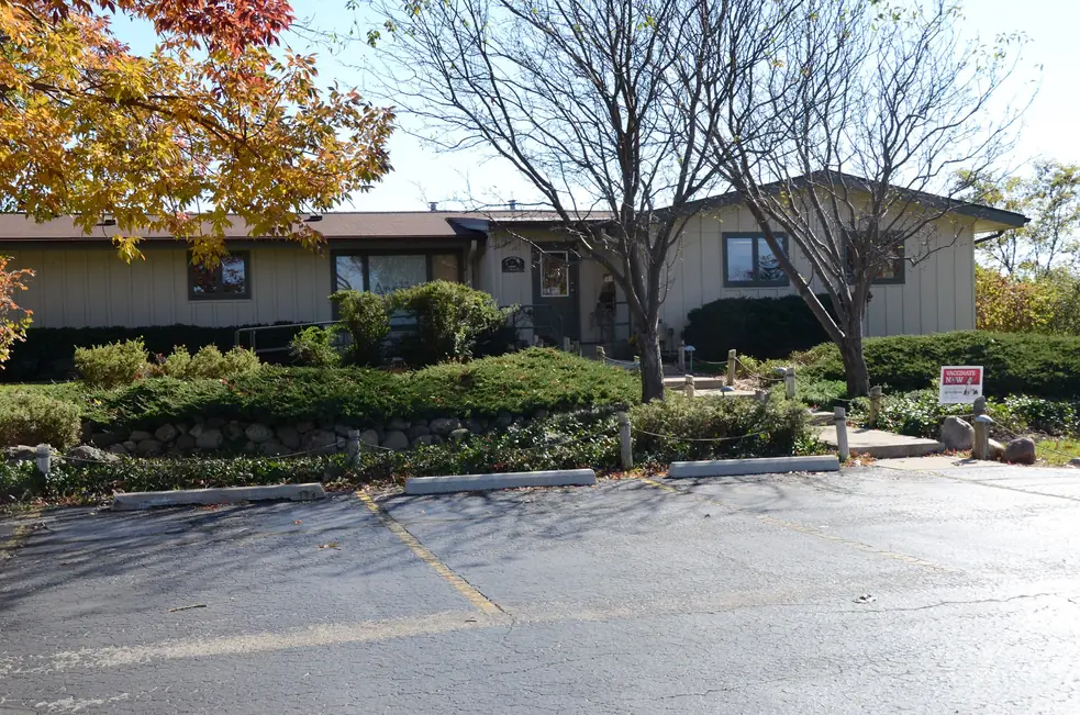 The Little Animal Hospital building seen from the parking lot, with a stone retaining wall and evergreen plantings